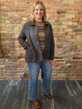 Model wearing dark quilted barn jacket with brown collar and trim