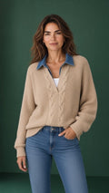 Beige cable-knit V-neck sweater with blue denim collar and long sleeves, styled with jeans.