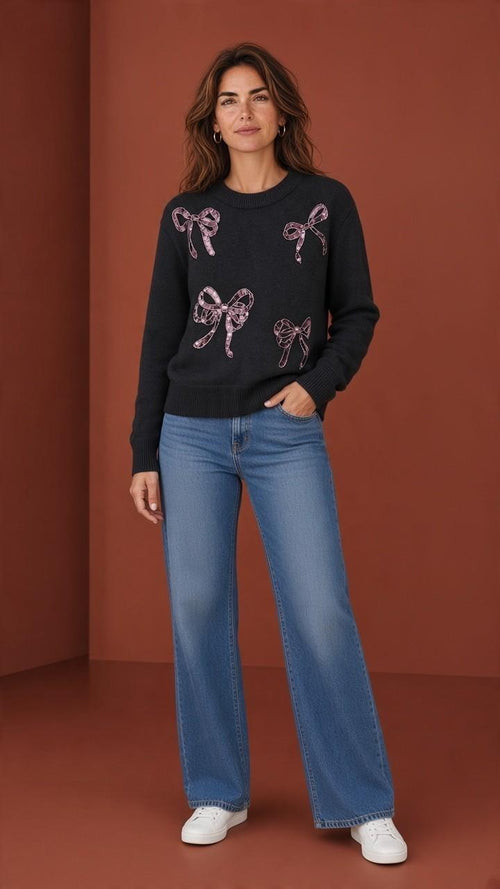 Black sequin bow crewneck sweater styled with blue jeans.