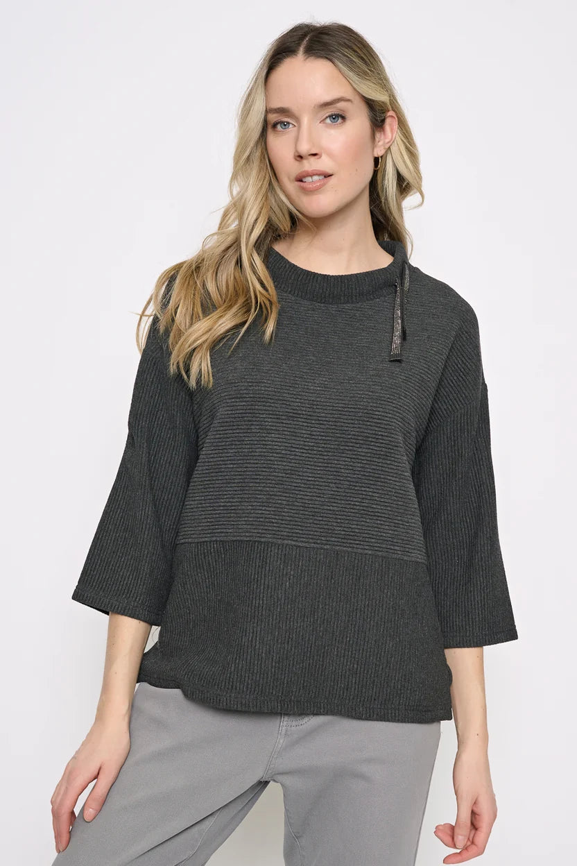Model wearing a charcoal drawstring-neck top with a sparkling neckline detail and three-quarter sleeves