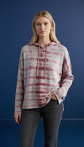 Model wearing a mauve, blush, and cream tie-dye hooded knit top