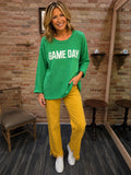Model wearing green Game Day sweater with mustard wide-leg pants