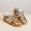 Corkys Heads Up gold metallic sneaker pair on cream background